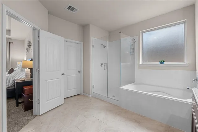 a bedroom with a bed flat screen tv and a large window