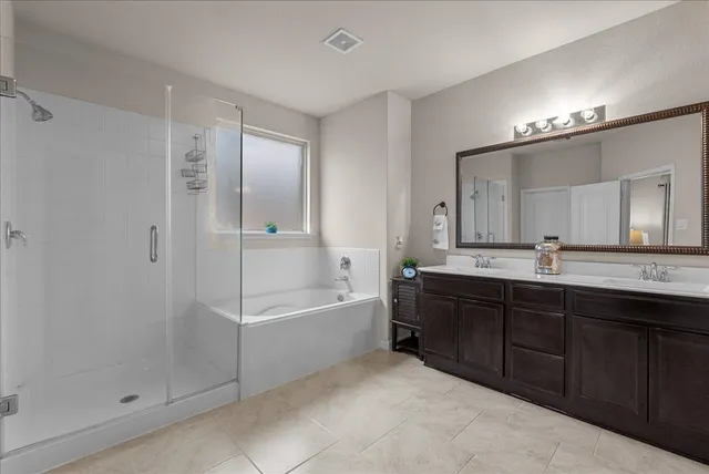 a spacious bathroom with a tub sink and mirror