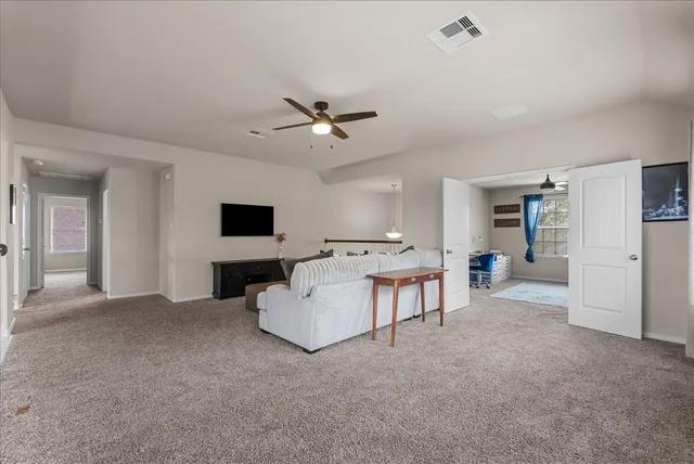a living room with furniture and a ceiling fan