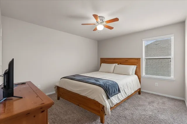 a living room with furniture and a ceiling fan
