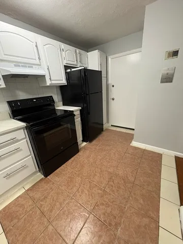 a kitchen with a refrigerator stove and cabinets