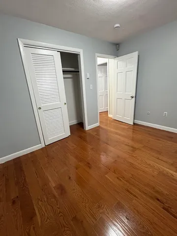 an empty room with wooden floor and closet