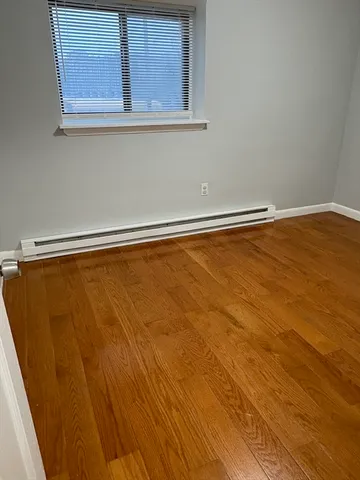a view of a room with wooden floor and a window