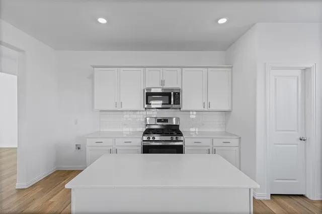 a kitchen with a sink and white cabinets