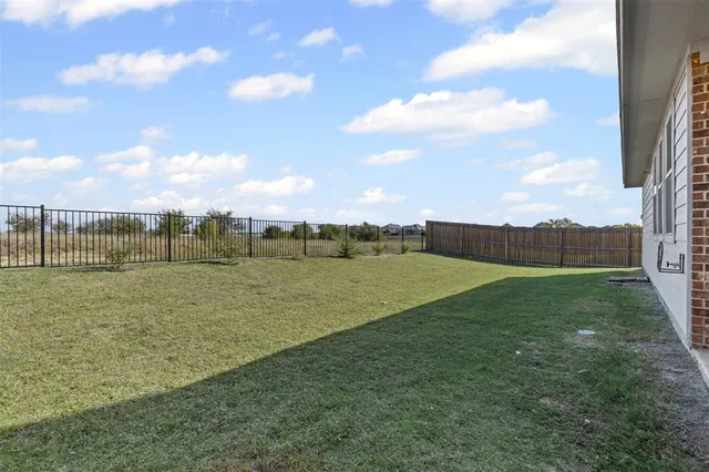 a view of green field with house in background