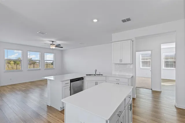 a kitchen with cabinets wooden floor and a dining table