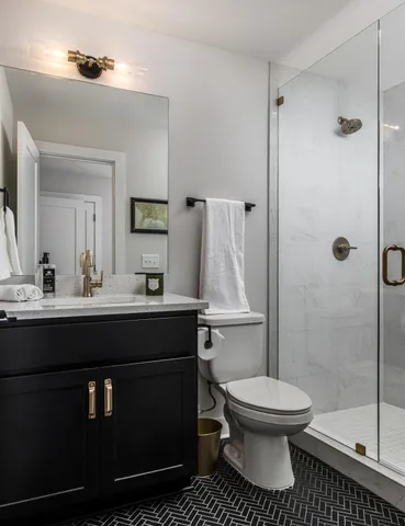 a bathroom with a sink a toilet and shower