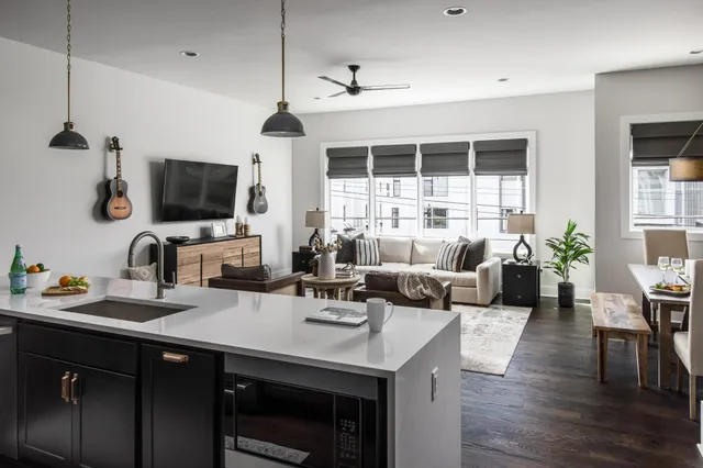 a living room with furniture a flat screen tv and a window