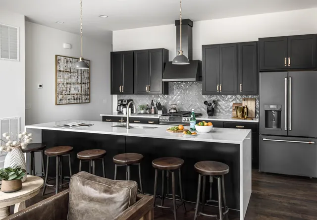 a kitchen with stainless steel appliances a sink a stove a refrigerator and cabinets