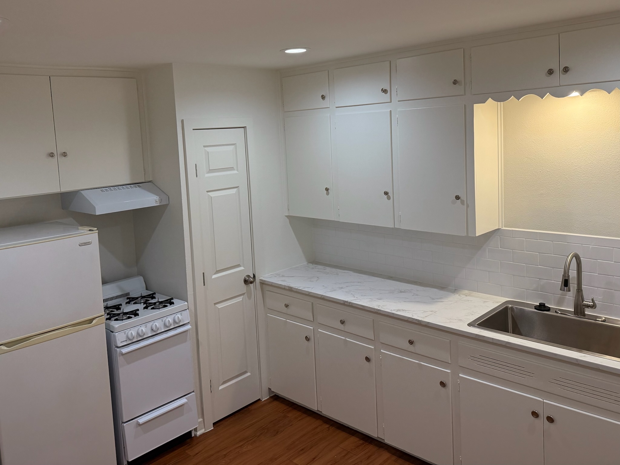 2514 West 12th Street, Unit D Austin, TX 78703 - Photo 3 of 11 a kitchen with cabinets and white appliances