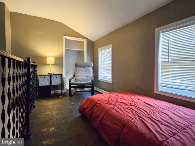 a bed sitting in a bedroom next to a window