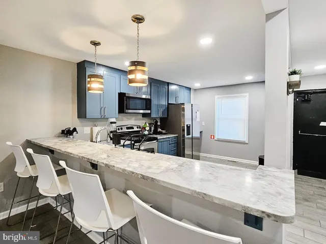 a kitchen with kitchen island a sink stove and refrigerator