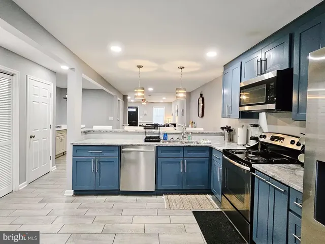a kitchen with stainless steel appliances granite countertop a stove a sink and a microwave