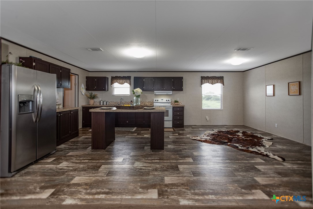 1849 Royal Road Port Lavaca, TX 77979 - Photo 16 of 40 a kitchen with granite countertop a refrigerator and a stove top oven
