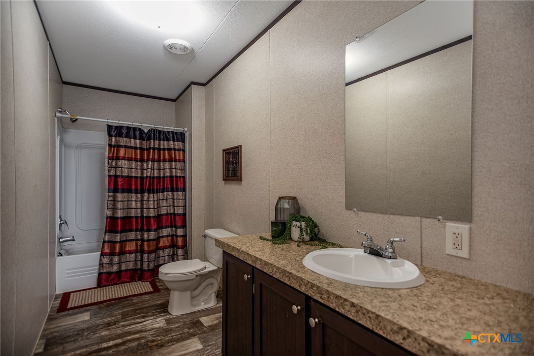 1849 Royal Road Port Lavaca, TX 77979 - Photo 21 of 40 a bathroom with a granite countertop sink toilet a mirror and shower