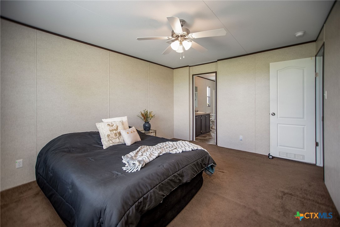 1849 Royal Road Port Lavaca, TX 77979 - Photo 25 of 40 a bedroom with a bed and a chandelier