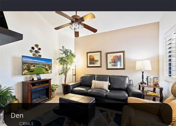 a living room with furniture a flat screen tv and a wall painting