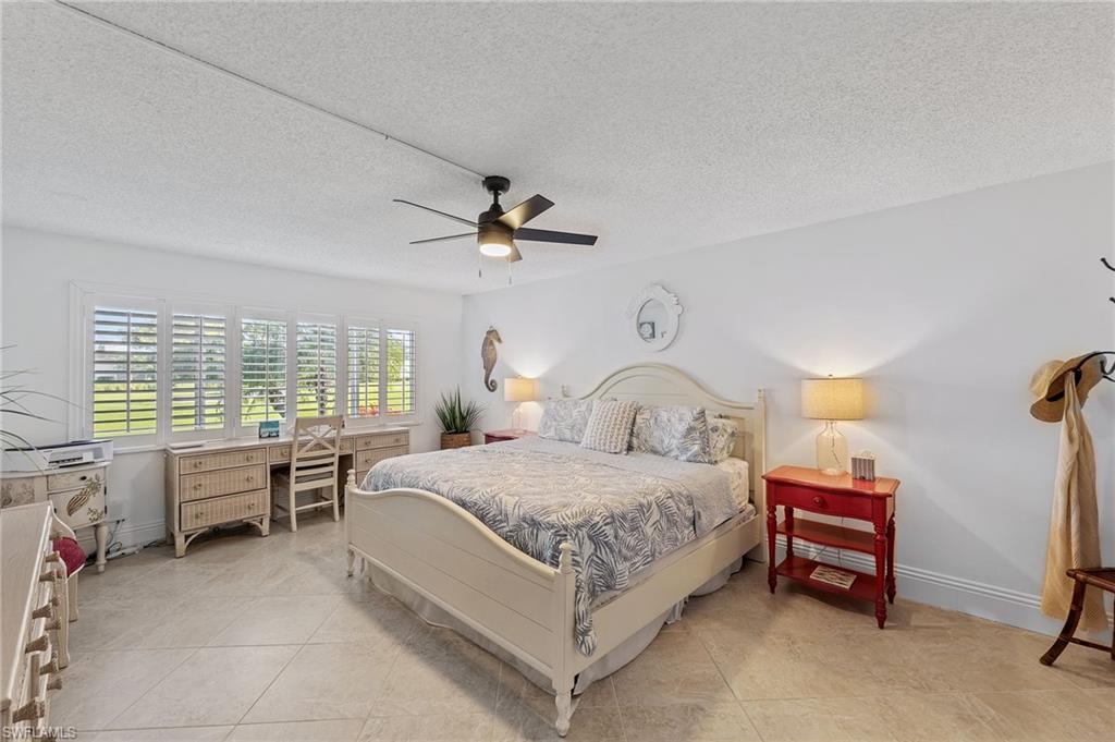 171 Quails Nest Road, Unit 3 Naples, FL 34112 - Photo 22 of 50 a bedroom with a bed and a chandelier