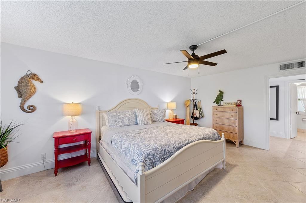171 Quails Nest Road, Unit 3 Naples, FL 34112 - Photo 23 of 50 a bedroom with a bed and a chandelier