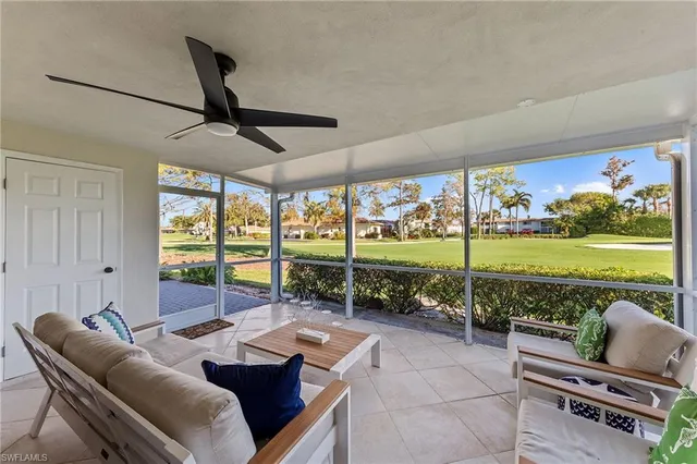 a living room with furniture and a floor to ceiling window