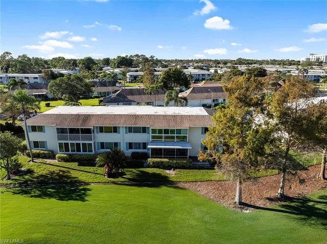 a view of a house with a big yard and large trees