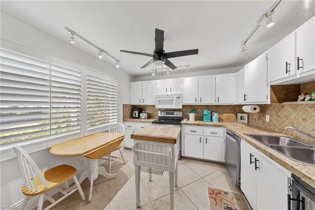 a kitchen with furniture a center island stainless steel appliances cabinets and a window