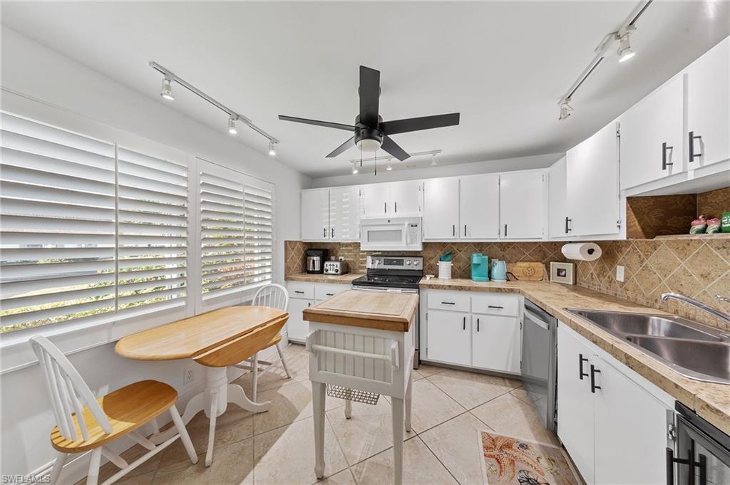 171 Quails Nest Road, Unit 3 Naples, FL 34112 - Photo 6 of 50 a kitchen with furniture a center island stainless steel appliances cabinets and a window