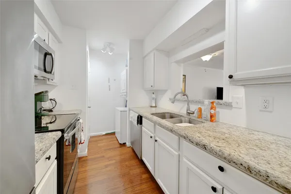 a spacious kitchen with stainless steel appliances granite countertop a sink and cabinets