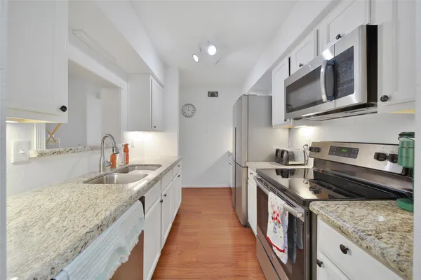 a kitchen with stainless steel appliances granite countertop a sink and a stove