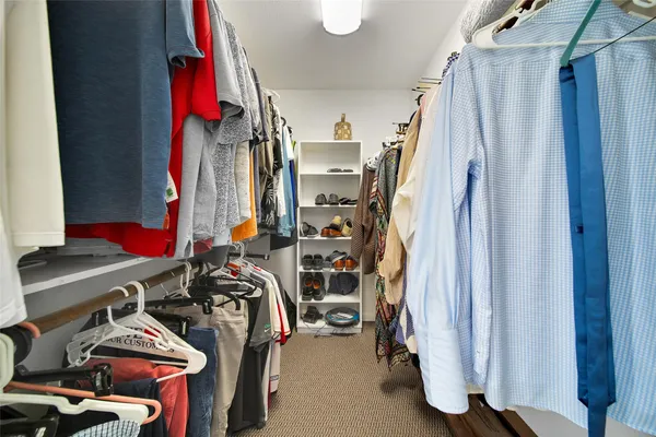 a view of walk in closet with clothes