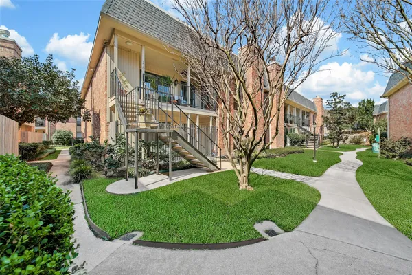 a view of a house with garden and trees