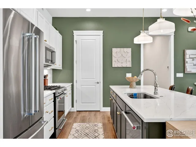 a kitchen that has a lot of cabinets and wooden floor
