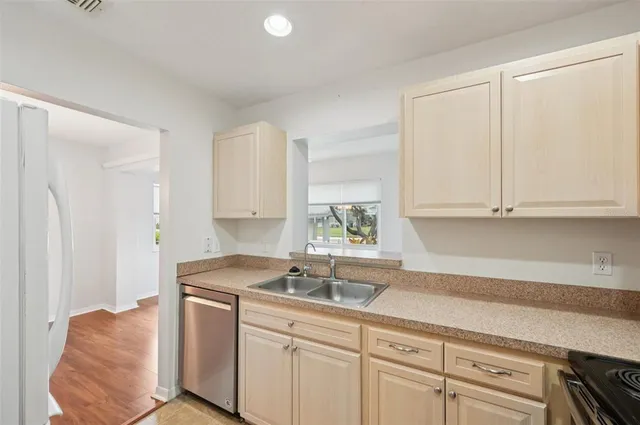 a kitchen with stainless steel appliances granite countertop a sink a stove and white cabinets