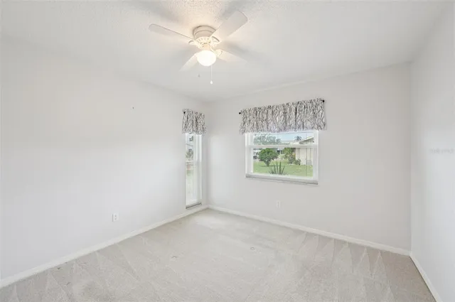 a view of a big room with closet and a ceiling fan