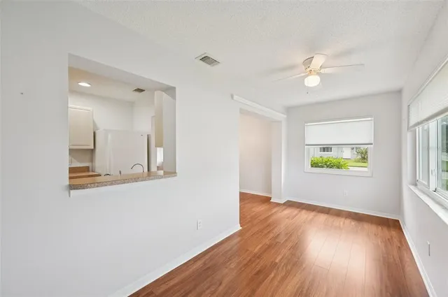 a view of room with window ceiling fan and hardwood floor