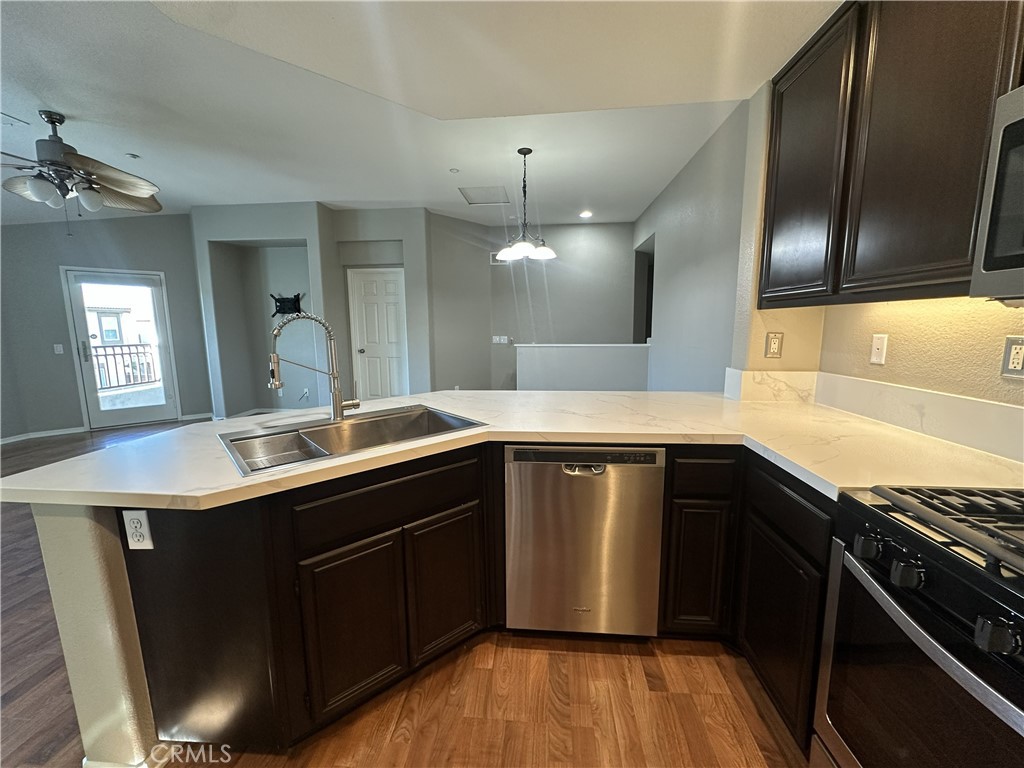 25190 Crest Haven Street, Unit 2 Murrieta, CA 92562 - Photo 11 of 30 a kitchen with a sink stove and cabinets