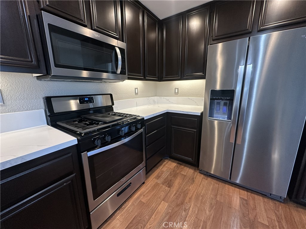 25190 Crest Haven Street, Unit 2 Murrieta, CA 92562 - Photo 12 of 30 a kitchen with granite countertop stainless steel appliances and wooden cabinets