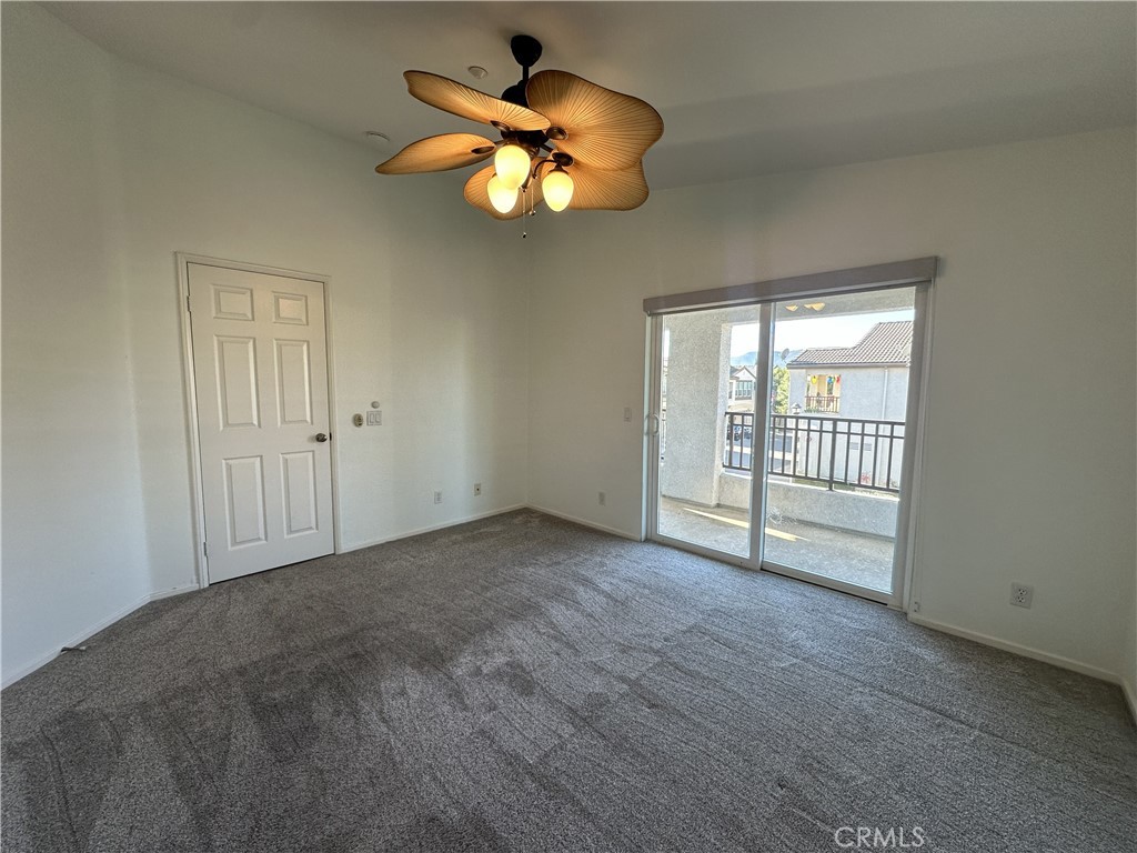 25190 Crest Haven Street, Unit 2 Murrieta, CA 92562 - Photo 18 of 30 an empty room with a chandelier fan and windows
