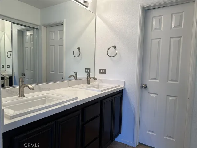 a bathroom with a double vanity sink and a mirror