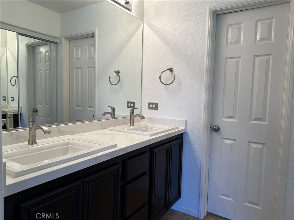 25190 Crest Haven Street, Unit 2 Murrieta, CA 92562 - Photo 20 of 30 a bathroom with a double vanity sink and a mirror