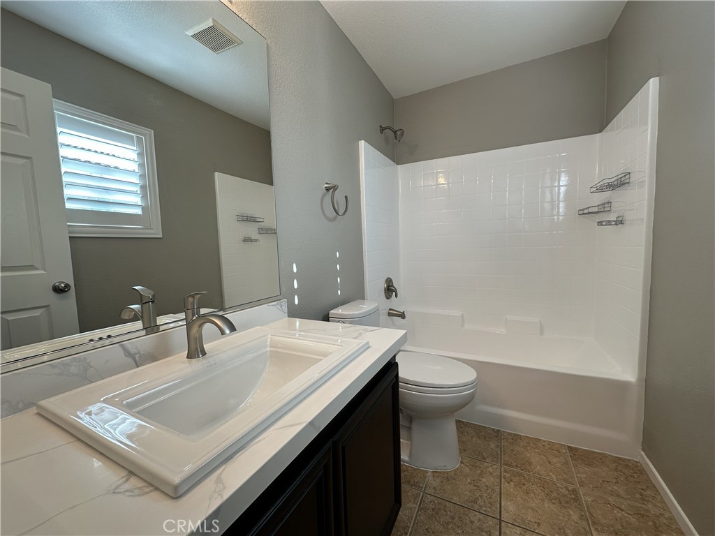 25190 Crest Haven Street, Unit 2 Murrieta, CA 92562 - Photo 28 of 30 a bathroom with a sink a toilet a mirror and shower