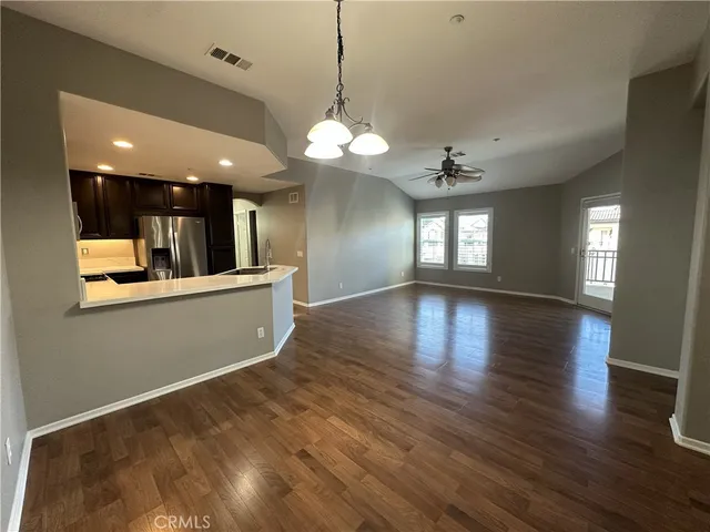a view of a big room with wooden floor and kitchen