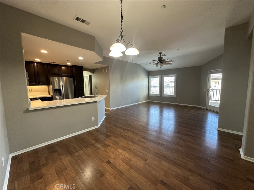 25190 Crest Haven Street, Unit 2 Murrieta, CA 92562 - Photo 6 of 30 a view of a big room with wooden floor and kitchen