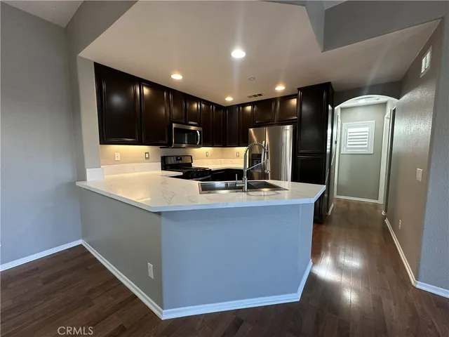 a large kitchen with stainless steel appliances a large counter top