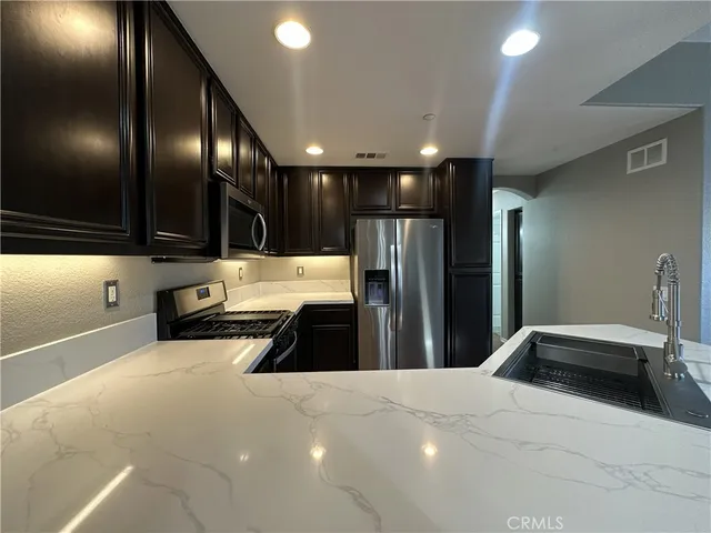 a kitchen with stainless steel appliances a refrigerator and a sink