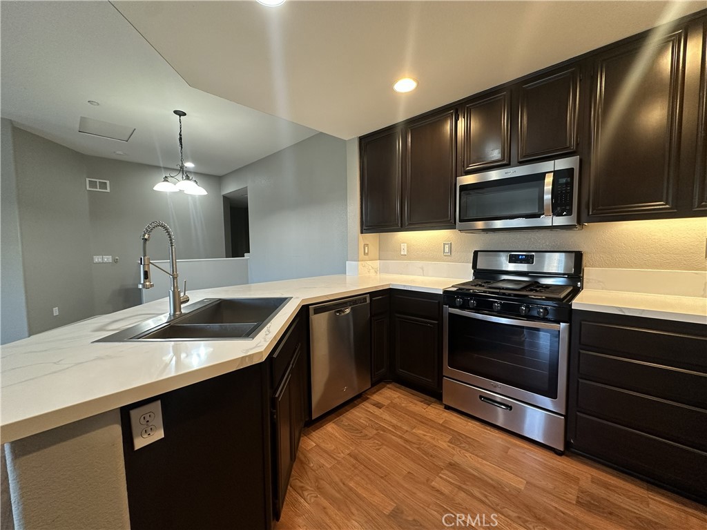 25190 Crest Haven Street, Unit 2 Murrieta, CA 92562 - Photo 10 of 30 a kitchen with granite countertop stainless steel appliances and wooden cabinets