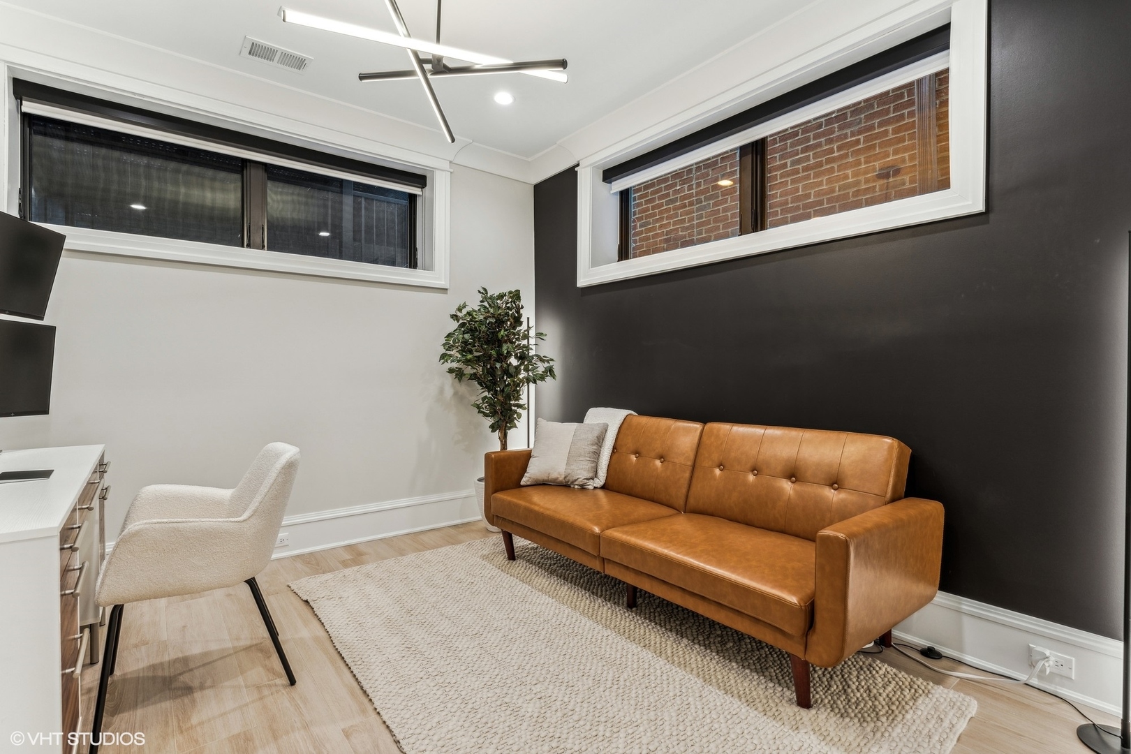 2034 North Mohawk Street, Unit 1 Chicago, IL 60614 - Photo 21 of 26 a blue couch sitting in a living room next to a window
