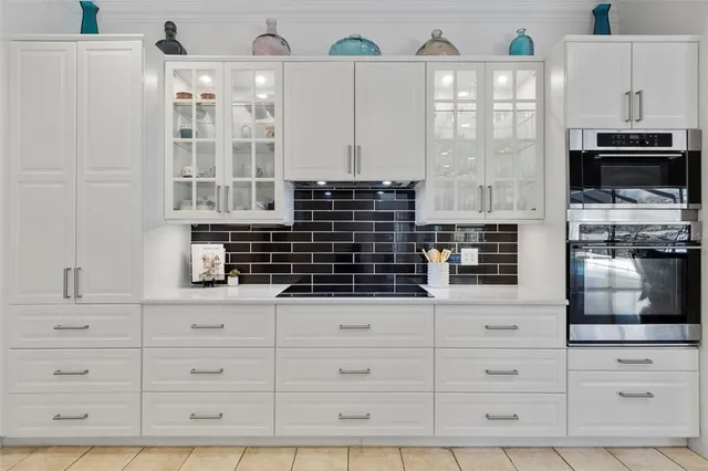 a kitchen with white cabinets and appliances