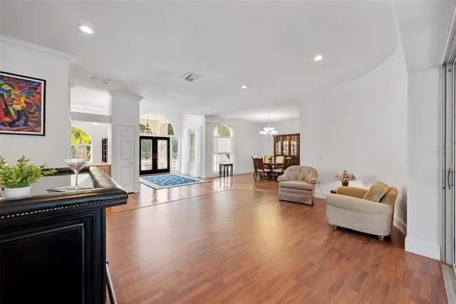 a large white kitchen with kitchen island a large counter top and stainless steel appliances