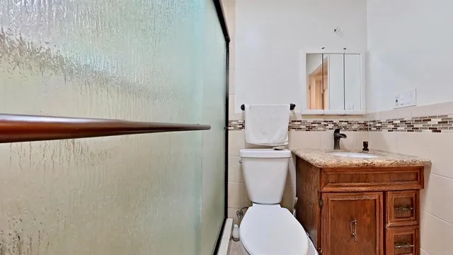 a bathroom with a granite countertop toilet sink and mirror